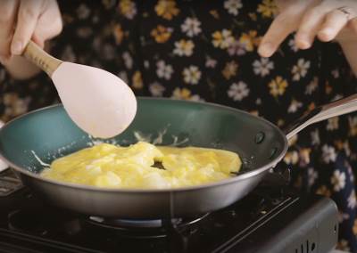  Žena sprema kajganu u tiganju 