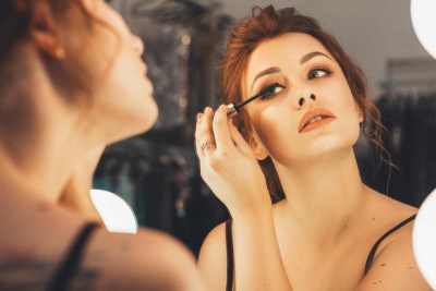  Žena se šminka u ogledalu 